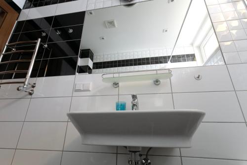 尤尔马拉Cozy apartments in Bulduri的白色的浴室设有水槽和窗户。