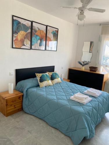 卡拉德莫尔Apartamento La cala 2的一间卧室配有蓝色的床和两个枕头
