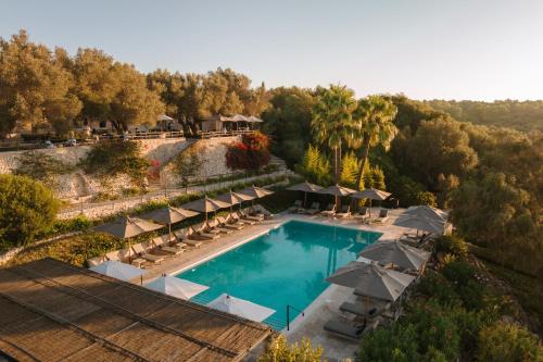 蒙图伊里Finca Serena Mallorca, Small Luxury Hotels的享有带遮阳伞的度假村游泳池的空中景致
