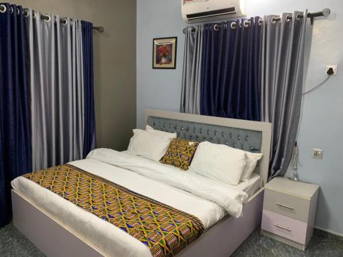 AbakalikiGarden View Holiday Cottage的一间卧室配有一张蓝色窗帘的床