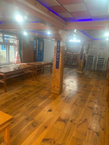 ChaunrikharkaBuddha Lodge的配有木桌和椅子的房间