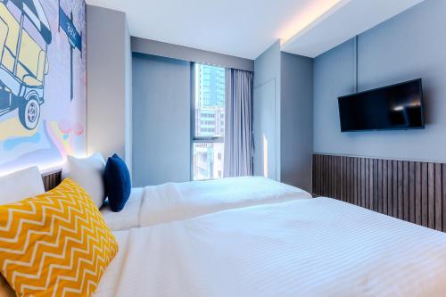 曼谷lyf曼谷素坤逸8号共享公寓的一间卧室配有两张床和一台平面电视