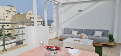 苏塞Luxury penthouse in Sousse的阳台配有沙发和桌子。