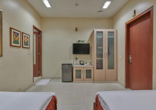 孟买Elphinstone Hotel的酒店客房设有两张床和电视。