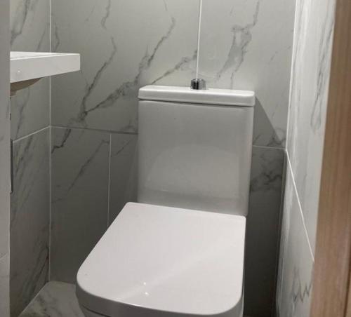SurbitonPeaceful Home Berrylands Surbiton Surrey UK - Free Parkings的浴室设有白色卫生间和大理石墙壁。