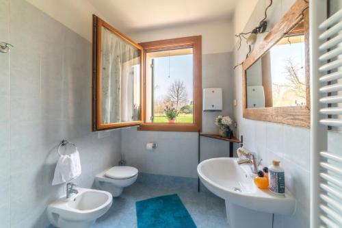 特雷维索Agriturismo Al Botteniga的一间带两个盥洗盆、卫生间和窗户的浴室