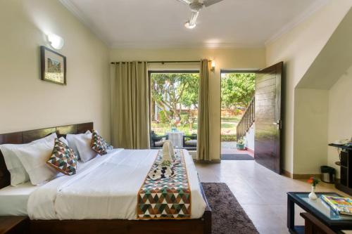 兰纳加Hridey Retreat Resort的一间卧室设有一张大床和滑动玻璃门