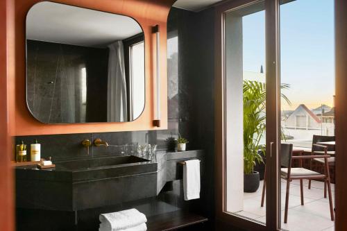 马德里Thompson Madrid, by Hyatt的一间带水槽和镜子的浴室