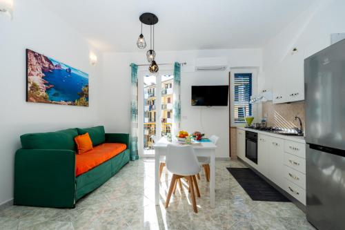 马奥莱Divina suite Cavaliere的一间带绿色沙发的客厅和一间厨房