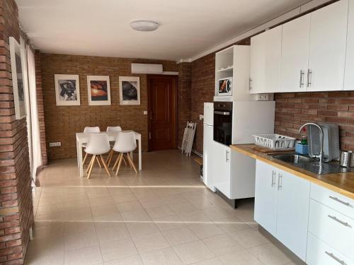格拉诺列尔斯APARTAM GRANOLLERS的厨房配有白色橱柜和桌椅