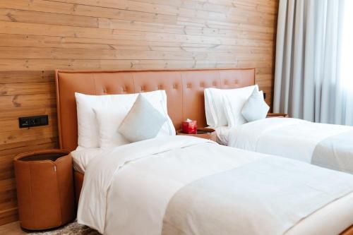 ChimganLe Chalet by Amirsoy的配有白色枕头的酒店客房内的两张床