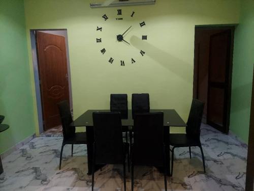 瓦加杜古Cool meuble 2的一间设有桌子和墙上时钟的餐厅