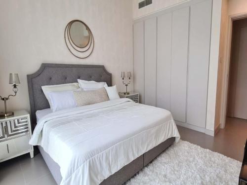 Durrat Al BahrainMarassi shores - 310的白色卧室设有一张大床和镜子