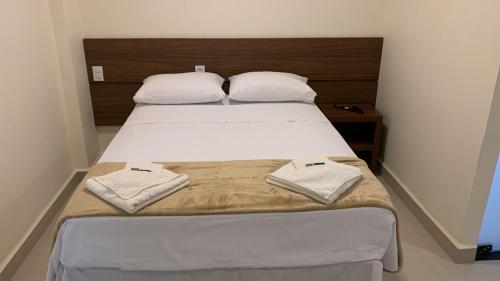 AlexâniaLazzaru's Hotel的一间卧室配有一张床,上面有两条毛巾