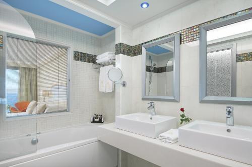 依克希亚中庭铂金水疗度假酒店的白色的浴室设有两个盥洗盆和镜子