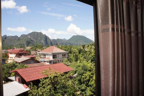 万荣ViengSaVanh Hotel的从山景城市的窗户欣赏美景