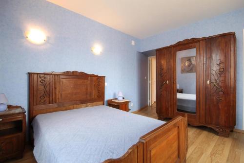 Bétoncourt-les-MénétriersGîte Ai Ouillotte的一间卧室配有一张床和一个木制橱柜