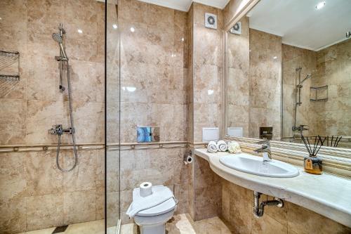 金沙Dreams in La Mer的带淋浴、卫生间和盥洗盆的浴室