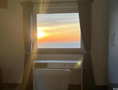 阿纳卡普里B&B La Danza del Mare的浴室设有窗户,位于卫生间上方,享有日落美景
