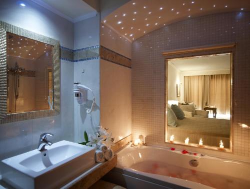 拉卡尼亚泰拉索温泉度假&中庭名誉别墅酒店的一间带浴缸和大镜子的浴室