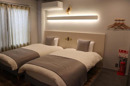 京都ホテル SHUNJU Dosse 1日1組様限定的配有大窗户的酒店客房内的两张床