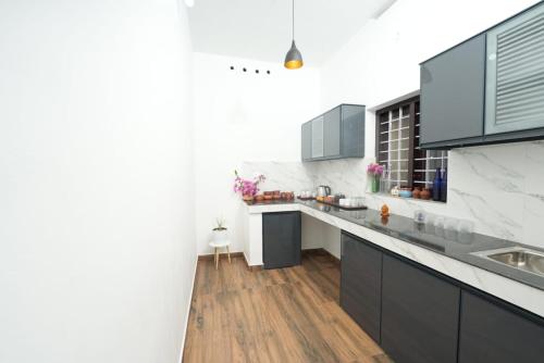 瓦尔卡拉VILLA MANTRAA的厨房拥有白色的墙壁和木地板