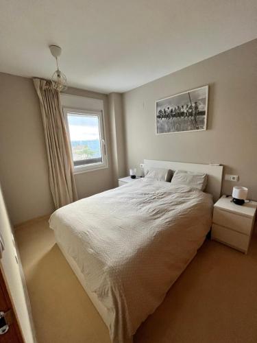 罗尔丹Las Terrazas De La Torre Golf的卧室设有一张白色大床和一扇窗户。