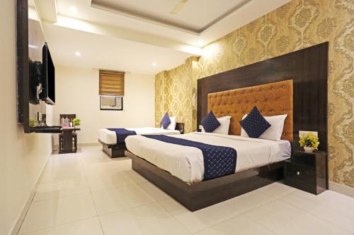 新德里The Rose Manor By Iconic Delhi International Airport的酒店客房设有两张床和电视。
