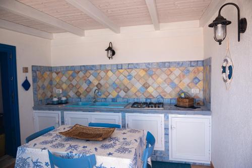 马里迪莫La terrazza del sole “ apartments “的厨房配有带蓝色椅子的桌子和水槽
