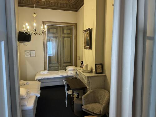 安特卫普Hotel Rubenshof的一间设有两张床、一张桌子和一把椅子的房间