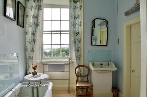 KilninianTorloisk House的一间带水槽和浴缸的浴室以及窗户。