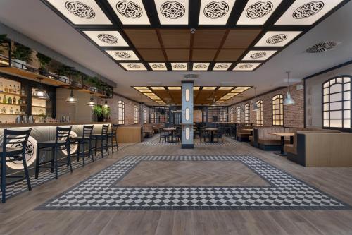 米泽德沃兹Juvena Hotel Wellness & SPA的一间带桌椅和天花板的餐厅