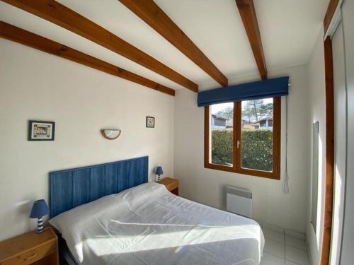 卡布勒通Villa Capbreton, 4 pièces, 6 personnes - FR-1-413-114的一间卧室设有蓝色的床和窗户。