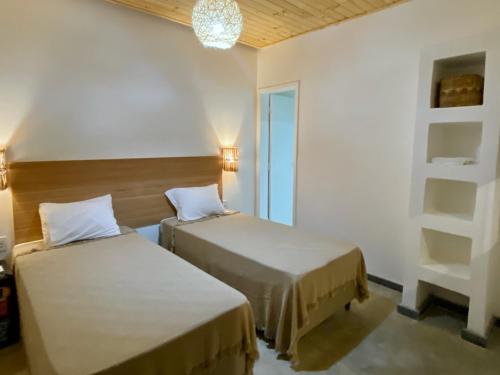 圣安娜杜里亚舒Pousada Panorama Cipo的客房设有两张床和吊灯。
