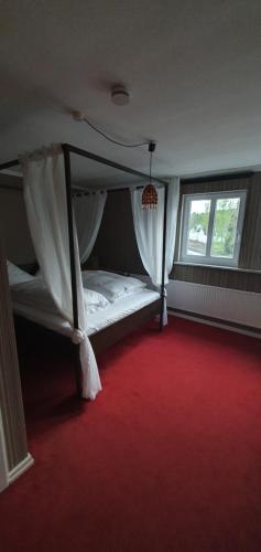 WissenAlte-post的一间卧室配有天蓬床和红地毯