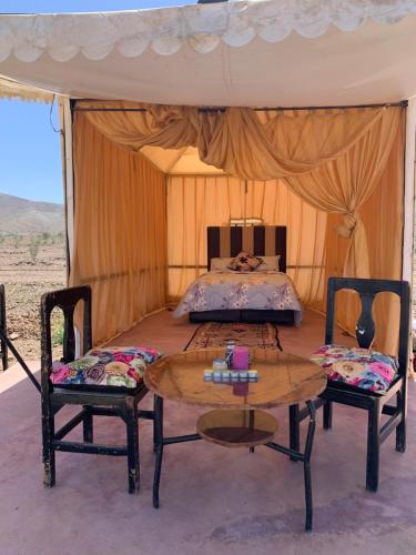 马拉喀什la casa de othmane的一间卧室配有一张床和两张桌子及椅子