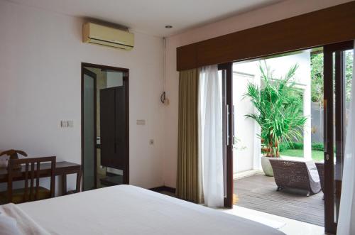 坎古Villa Umalas的一间卧室设有一张床和一个滑动玻璃门