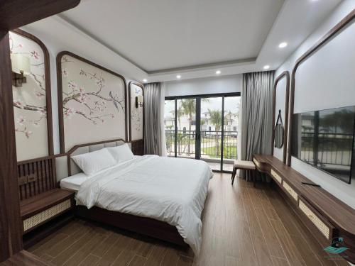 Cái RồngRosa Villa - Sonasea Vân Đồn的一间卧室配有一张带白色床单和窗户的床。