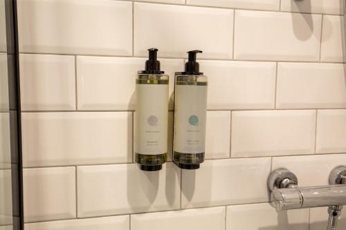 戈尔韦The Abbeygate Townhouse的浴室墙上的两瓶除臭剂