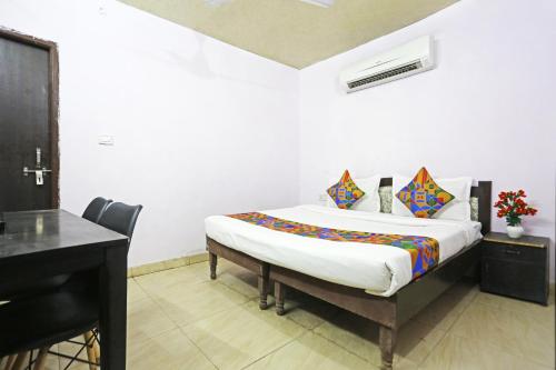 新德里Twamev Punjabi Bagh的一间卧室配有一张带书桌和钢琴的床。