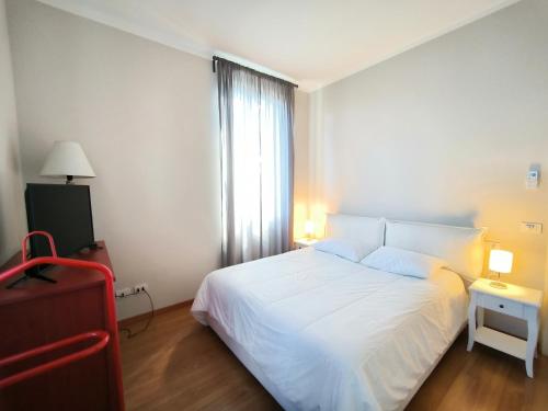 巴韦诺LA CASA GIALLA的卧室配有白色的床和窗户。