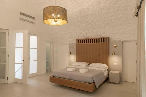 奥斯图尼Palazzo AD 1892 - SUITES & SPA的一间卧室配有一张大床和一盏灯
