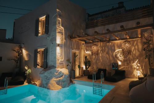 阿卡尼斯Manili Boutique Suites & Villas的夜间带游泳池的别墅