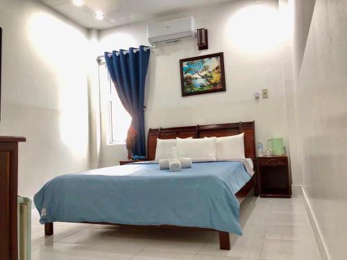 胡志明市Saigon Cozy2 Hotel的一间卧室配有一张带蓝色床单的床和一扇窗户。