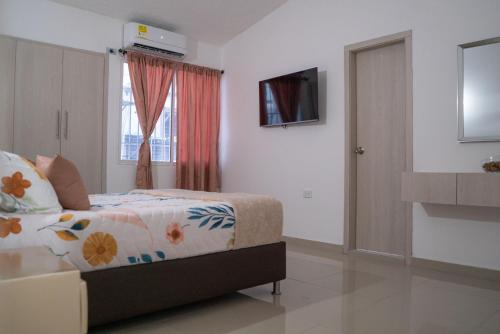 巴耶杜帕尔APARTAMENTO - AIRE ACONDICIONADO的一间卧室设有一张床、一台电视和一个窗口。