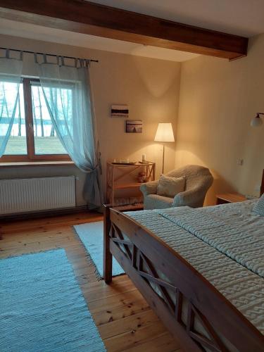 巴蒂泽Gustiņi的卧室配有床、椅子和窗户。