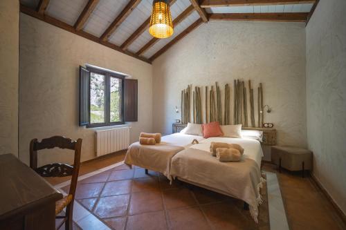 贝瑙汉Eco Hotel Cueva del Gato的一间卧室,床上放着两只动物