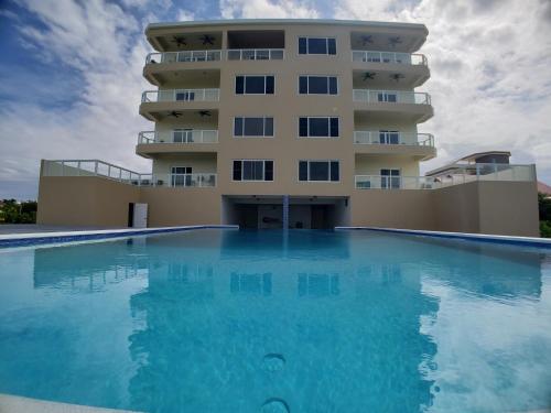 圣佩德罗Coconuts Caribe的大楼前设有游泳池的酒店
