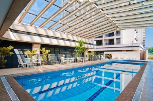 圣保罗H1503 Suíte Luxo Flat Hotel Aeroporto Congonhas的一座带玻璃天花板的游泳池和一座建筑