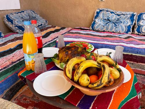 TattaMAISON D'HOTE DAR IMRANE的床上摆着一碗香蕉和水果的桌子